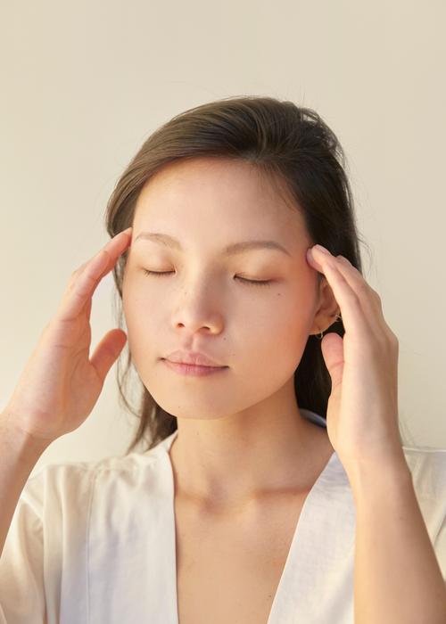 woman massaging her temples to relieve stress and anxiety