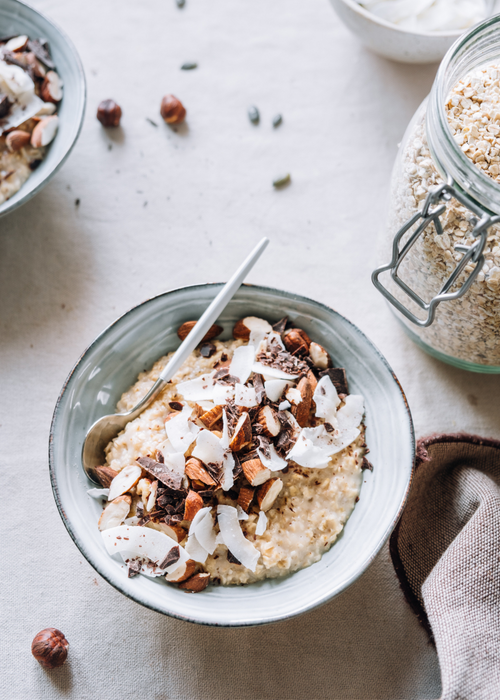 nutritious breakfast bowl of oats, coconut flakes, nuts and cacao