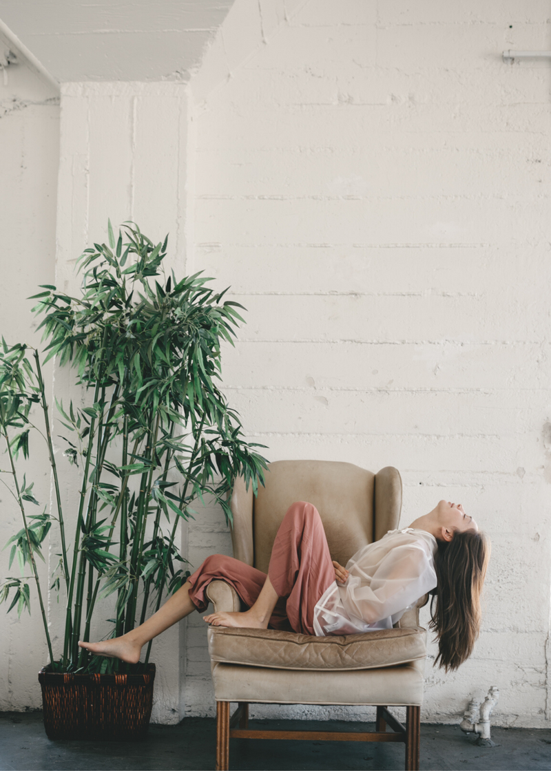 woman relaxing at home with a plant