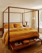 Bedroom with a wooden canopy bed and 100% french flax linen bedding in turmeric, terracotta and creme. - view