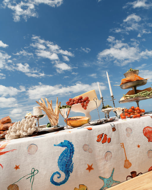 Table with seafood-themed decorations against a blue sky with clouds
