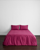 crumpled magenta fabric with soft folds and gentle shadows, creating a textured and subtly shiny look.