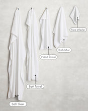 Two crisp white 100% cotton terry bath towels by Bed Threads hang on the wall, showcasing plush texture and absorbency—the perfect addition to your bathroom essentials. - view