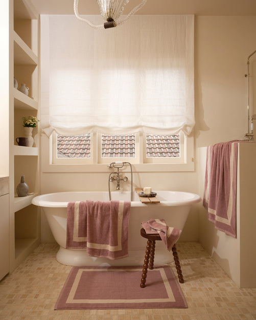 Neutral bathroom with freestanding bath tub and cotton terry towels in a lavender colour with creme border.