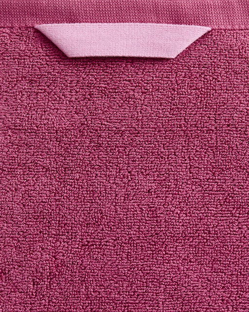 A close-up of the Bed Threads Berry 100% Cotton Terry Bath Towel shows its textured, plush pink fabric and a matching hanging loop at the top.