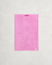 The Bubblegum 100% Cotton Terry Hand Towel by Bed Threads is a bright pink, rectangular, quick-drying 650GSM towel with a fabric loop and beige tag for easy hanging and added style. - view
