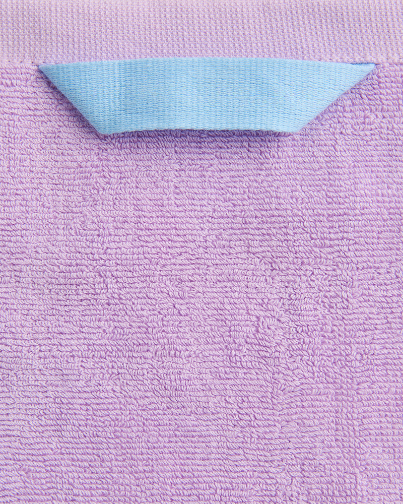 A close-up of the Bed Threads Violet 100% Cotton Terry Bath Towel Bundle shows its textured surface and a folded blue hanging loop at the top center.